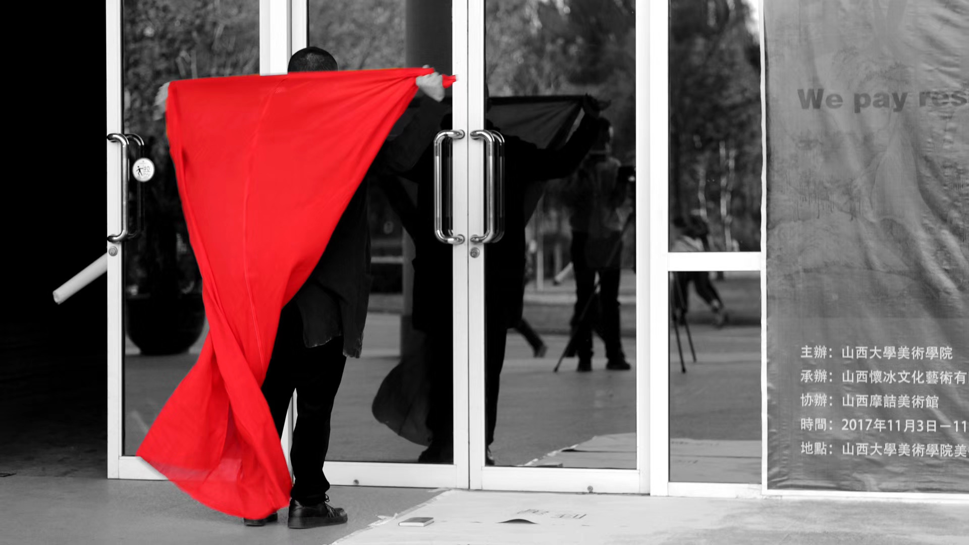 Artist stretching red cloth across academy entrance during Late performance